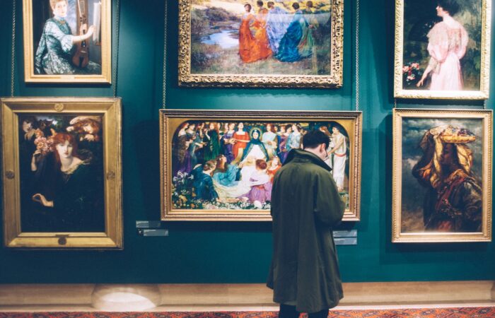 person standing near six paintings inside gallery